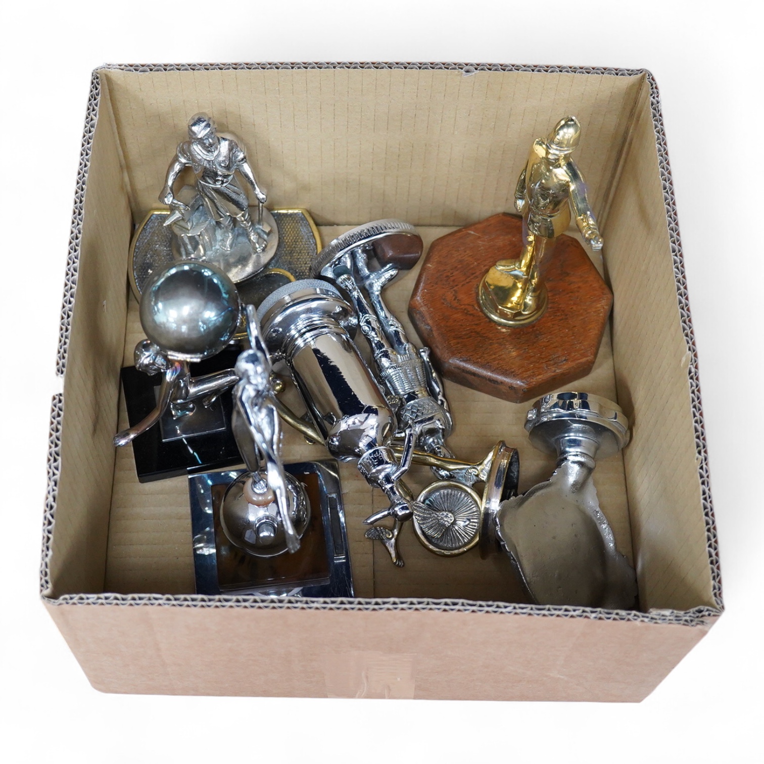 Five chrome and brass car mascots, including a knight, a policeman, a figure of Mercury, etc. together with two Art Deco table lighters as female figures, and an ashtray with the figure of a blacksmith (8)